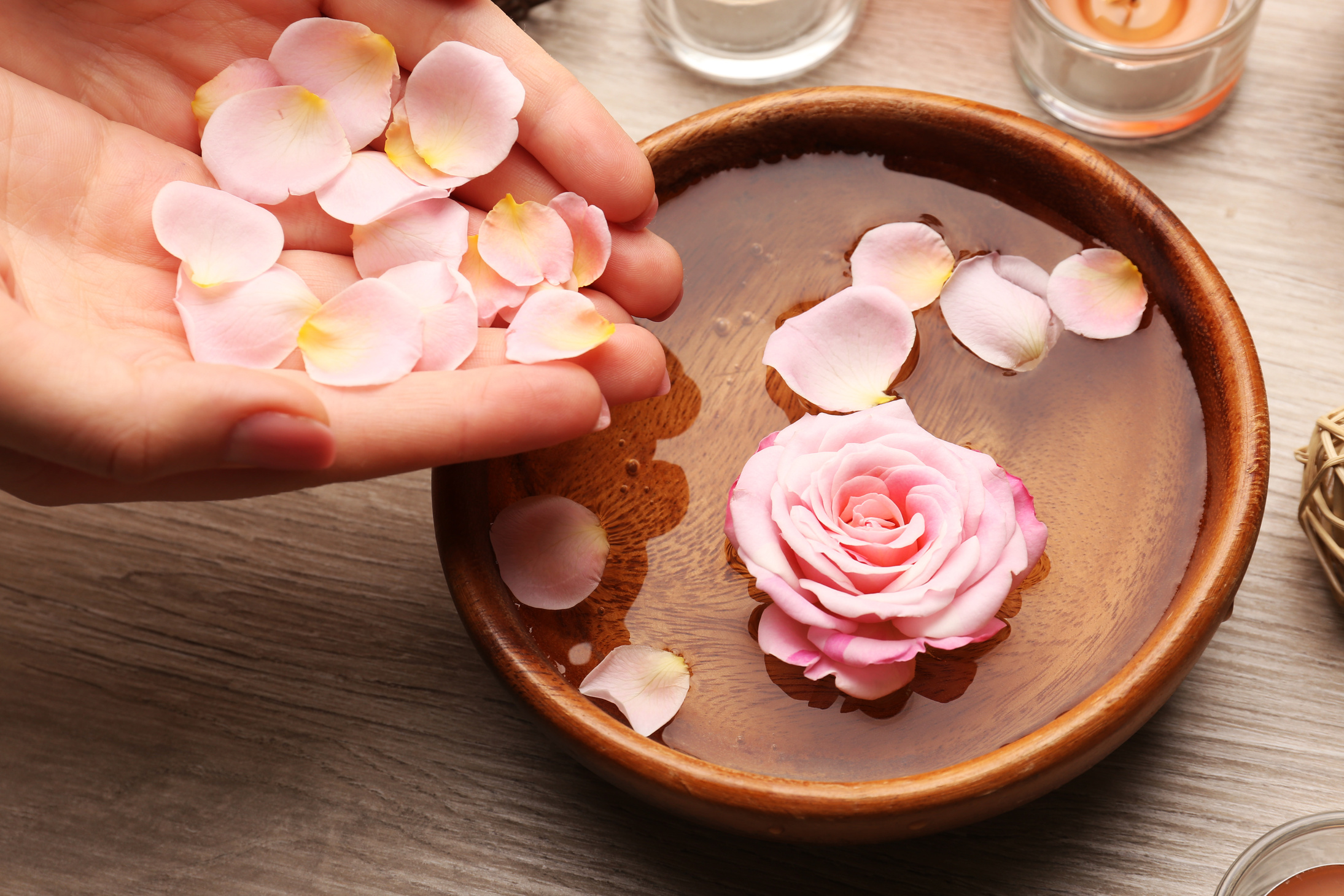 Hands and Bowl of Spa Water with Flowers
